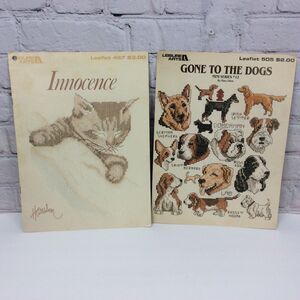 Leisure Arts Innocence & Gone To The Dogs Cross Stitch Pattern Booklets Set of 2